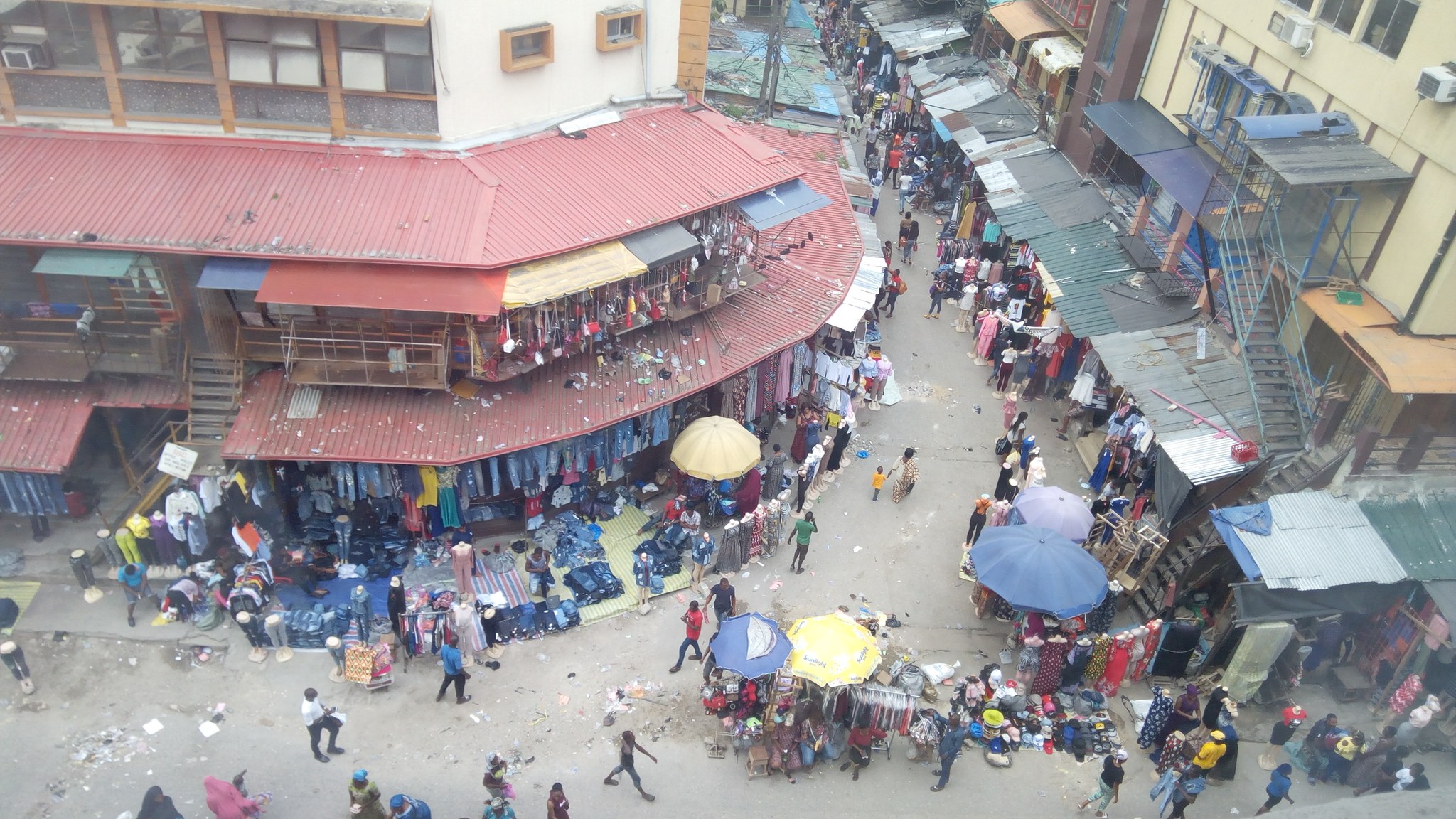 Aerial view of Balogun Market on Lagos Island, Nigeria, crowded with shoppers and traders under umbrellas and awnings.