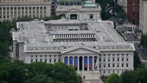 Aerial view of the US Treasury Department building in Washington, DC, with blue banners hanging between its columns.